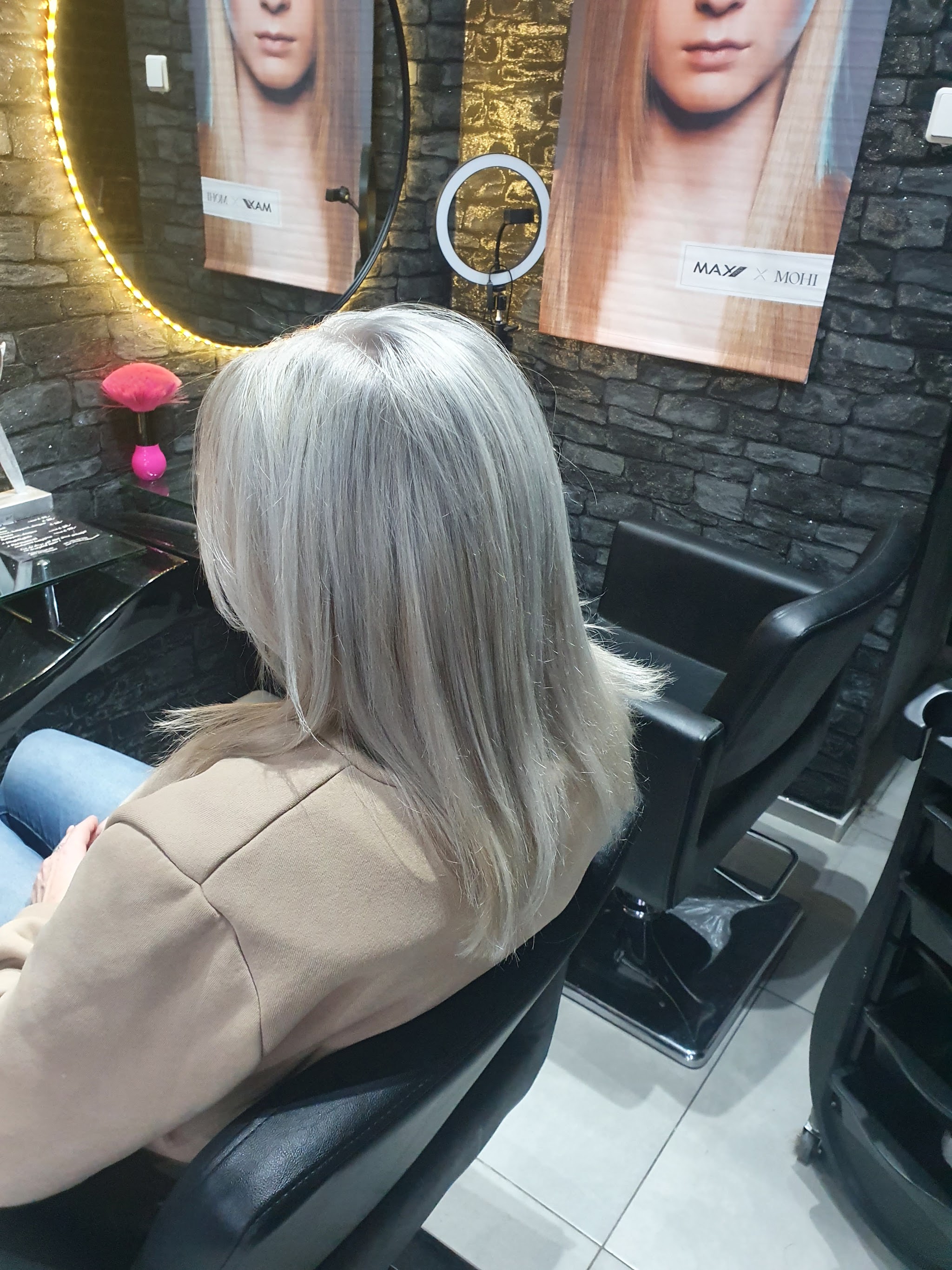 Zilverblond gekleurd haar bij een salonspiegel